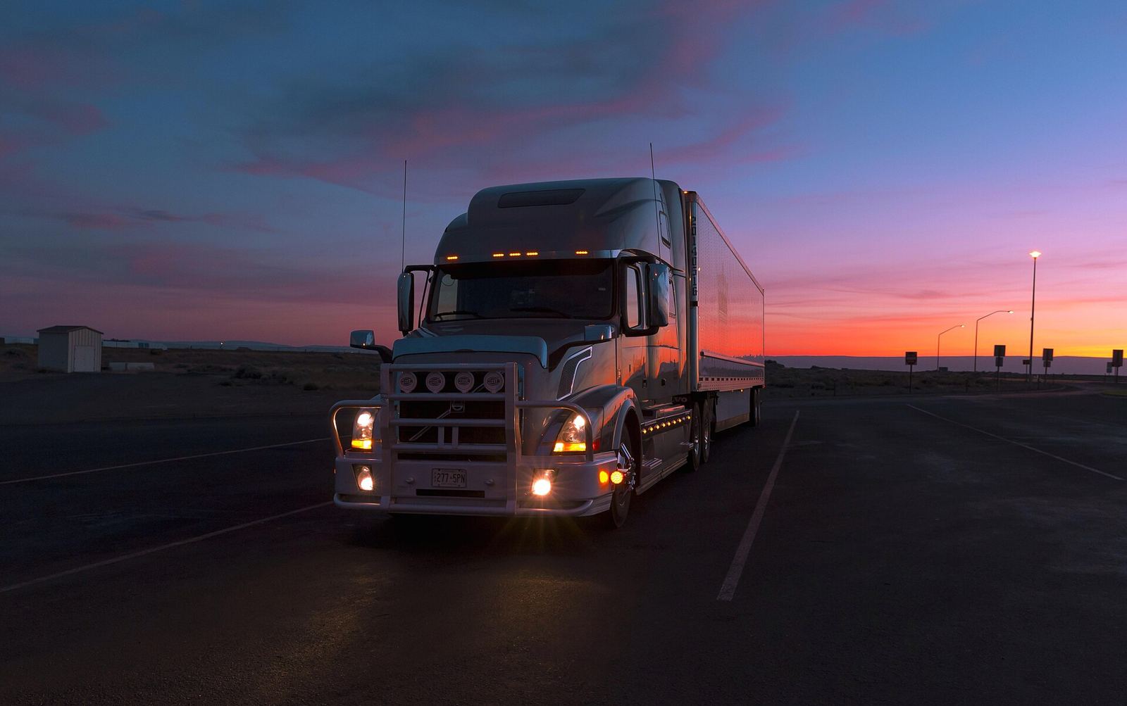 Volvo VNL sleeper with trailer at dusk
