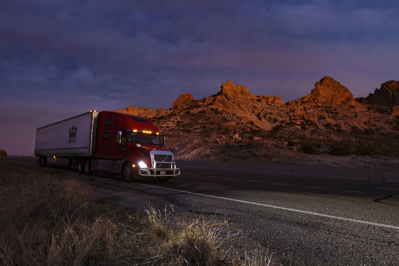 Volvo VNL with dry van on a desert highway at dusk
